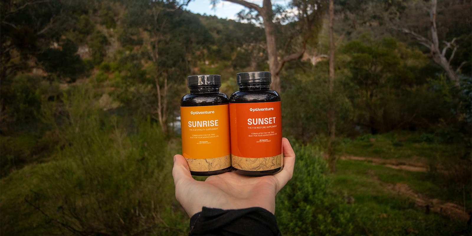 person holding two bottles of Optiventure nutrition capsules