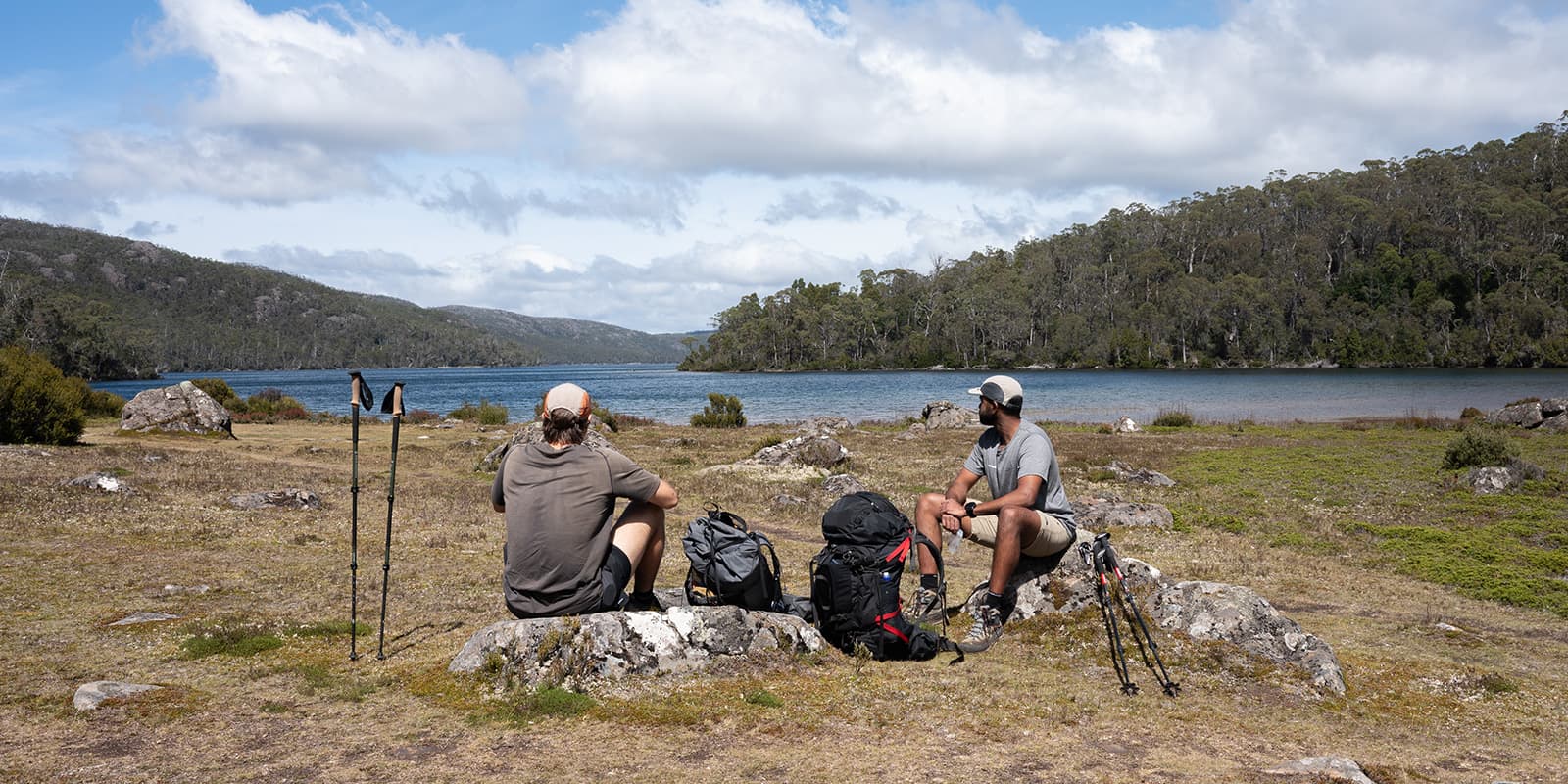 two hikers taking a break near lake