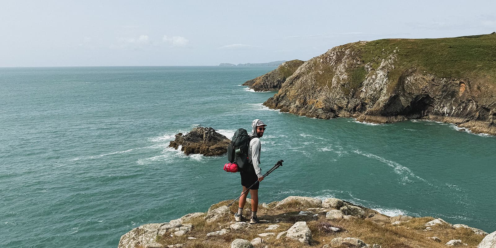 hiker overlooking the sea and coastline of Wales