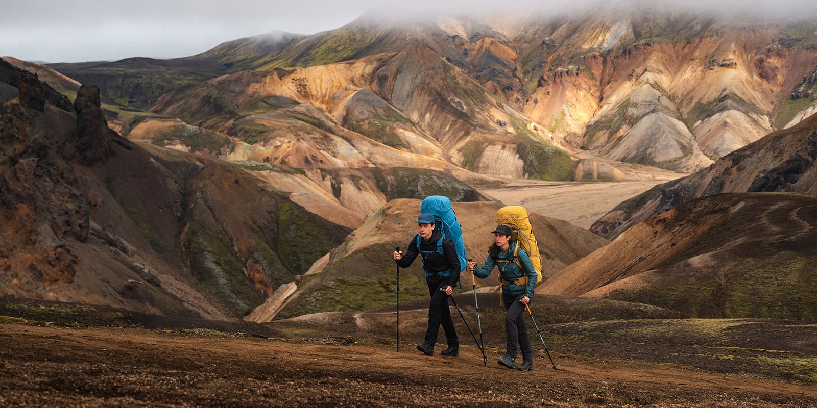 couple hiking the laugavegur trail in Iceland with colorful mountains in the background