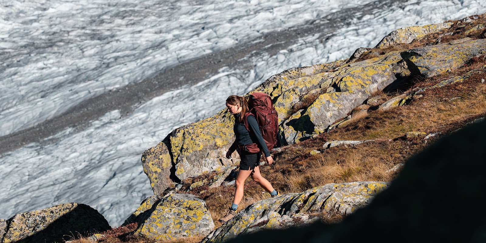 women hiking down mountain with glacier in the background
