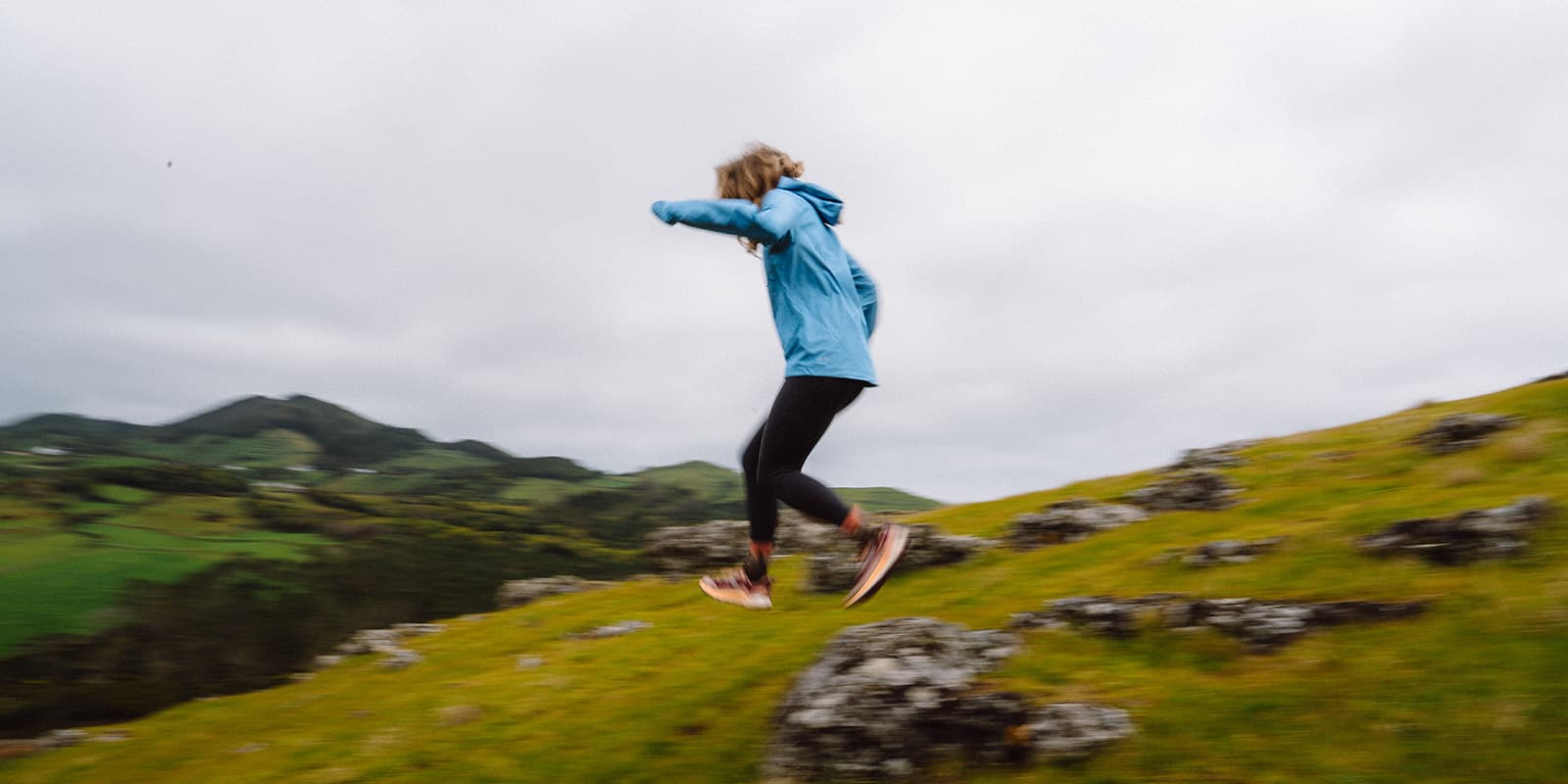 person running through green mountain landscape