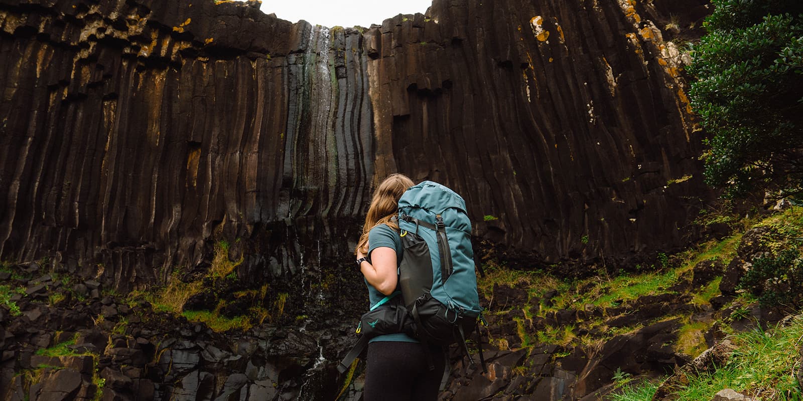 women looking up towards waterfall
